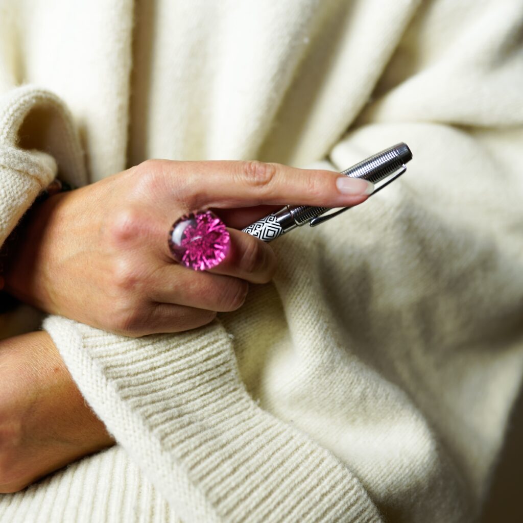 Plan sur la main d'isabelle avec un stylo et une bague